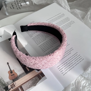 Close-up of pink tweed headband with thick sponge padding on an open magazine