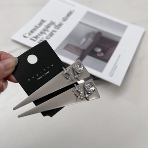 Détail de barrettes à cheveux en métal gris avec strass et étoiles sur carte nyunyu