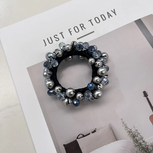 Détail de l'élastique à perles avec sphères argentées et accents en cristal bleu