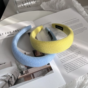 Wide wool knit padded headbands in blue and yellow colors with handmade label