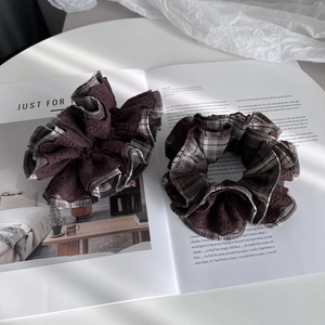 Detail of two oversized scrunchies in brown coffee lace and vintage plaid patterns