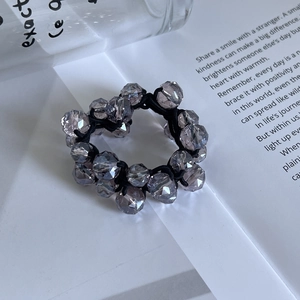 Détail d'un chouchou en cristal fait main avec perles facettées et cordon élastique noir