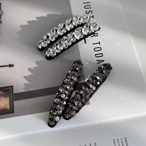 Dettaglio di fermagli per capelli in cristallo scintillante argento e grigio su una rivista