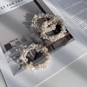 Elegantes 3er-Set Perlen- und Kristall-Haargummis auf einem Magazin für einen edlen Look
