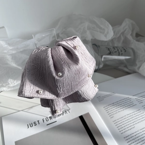 Detail of light purple pleated fabric hair claw with delicate white pearl accents