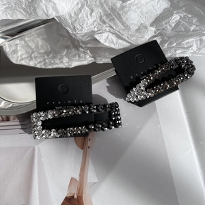 Detail view of rectangular and oval rhinestone hair clips on a silver tray with crystal shine
