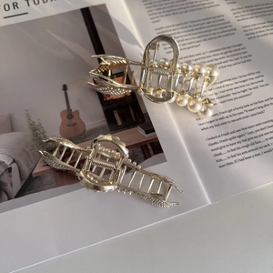 Détails de pinces à cheveux dorées élégantes avec perles sur un magazine chic