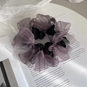 Detail of a purple organza hair scrunchie with layered mesh and sparkling rhinestones