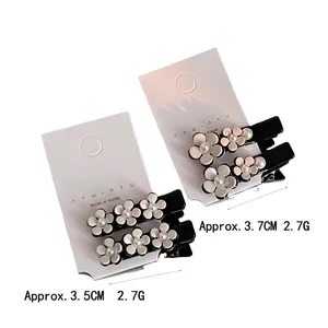 Set de barrettes camélia en acétate blanc avec perle artificielle sur base en résine noire