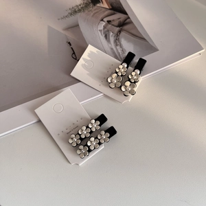 Détail de barrettes camélia en acétate style coréen avec perles sur carte de présentation