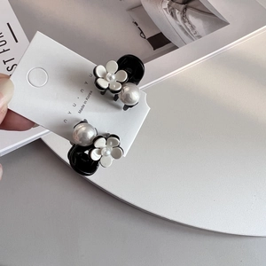 Dettaglio ravvicinato di una clip per capelli camelia con perla su acetato