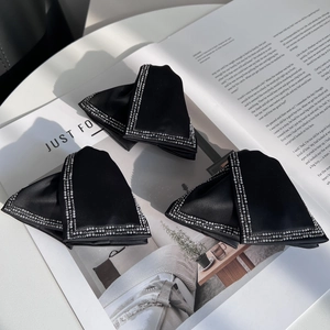 Detailed close-up of three black satin bow hair claws with pearl and rhinestone edges