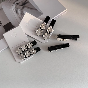 Ensemble de barrettes camélia avec perles artificielles sur carton blanc chic