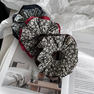 Detailed close-up of three floral fabric scrunchies with white small flower patterns