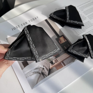 Elegant black satin bow hair claw with pearl and rhinestone edges for a chic look