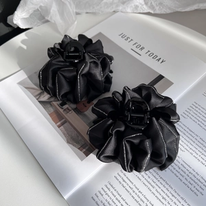 Detail of elegant black satin ruffle hair claw clip with silver rhinestone embellishments