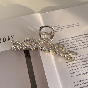 Detailweergave van de grote metalen haarklem met strass-steentjes op een tijdschrift