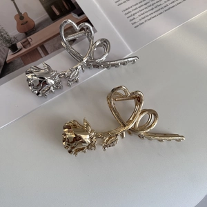 Close-up of gold and silver metal rose flower hair claws on a fashion magazine