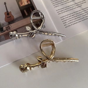 Detailed view of elegant gold and silver rose shaped hair claw clips on an open magazine