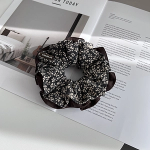Detail of floral fabric scrunchie with brown ruffled edges on a vintage magazine
