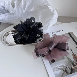 Vue détaillée de grandes pinces à cheveux nœud en organza noir et rose poudré doré