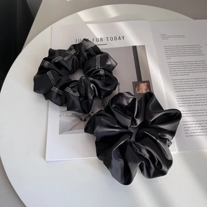 Detail of black satin scrunchies with rhinestones on a magazine background