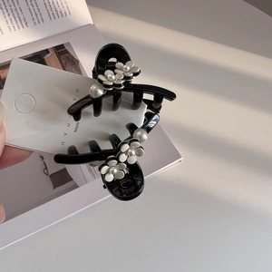 Elegant black hair claw clip featuring white acetate flowers and delicate center pearls