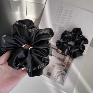 Elegant black satin scrunchie with sparkling rhinestones for versatile hair styling