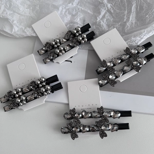 Elegant black metal hair clip set with dark grey rhinestones and pearls on white card