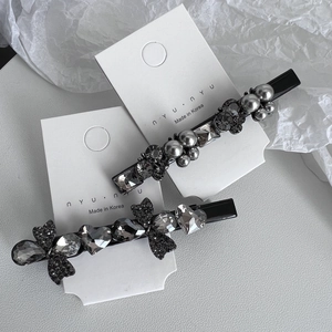 Elegant two-piece rhinestone hair clip set with grey pearls and crystal heart on display