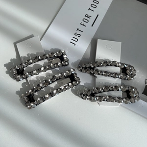 Detail of four-piece set with square and teardrop rhinestone hair clips on nyu nyu card
