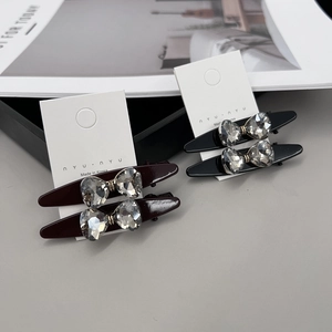 Détail de barrettes à cheveux avec nœuds en cristal en noir et rouge étincelant