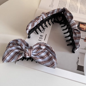 Classic blue and brown checkered bow hair clip set on a magazine background