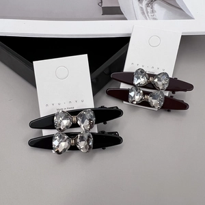 Détail de barrettes noeud en cristal de style coréen en noir et rouge vin sur carte