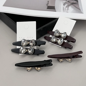 Barrettes à cheveux en cristal noir et rouge bordeaux sur un fond de mode élégant