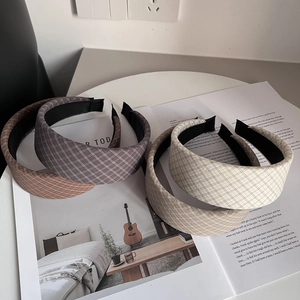 Classic checkered fabric padded headbands in four retro earth-tone colors on a magazine