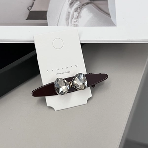 Détail de la pince à cheveux de style coréen avec nœud en cristal gris et bec de canard