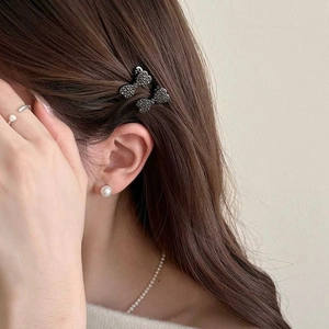 Dettaglio di fermagli per capelli a fiocco con strass neri e set di gioielli di perle