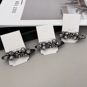 Detailed view of three luxury duckbill hair clips with grey pearls and sparkling rhinestones