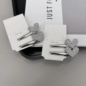 Détail de barrettes à cheveux en forme de cœur avec strass et clips en métal argenté