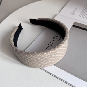 Detail of wide padded headband in khaki checkered fabric with soft foam texture