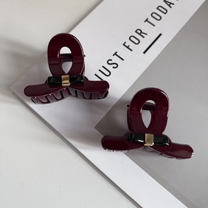 Set of two burgundy hair claw clips with elegant black bows and gold metal accents