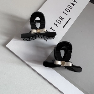 Set of two black glossy hair claw clips with cream bow and gold metal buckle detail