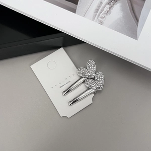 Gros plan de barrettes à cheveux en forme de cœur avec strass sur carte de marque