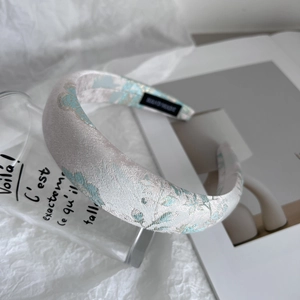 Detail of light blue and silver jacquard floral texture on a padded wide headband