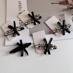 Detail of luxury rhinestone bow hair clips set with premium black metal duckbill base