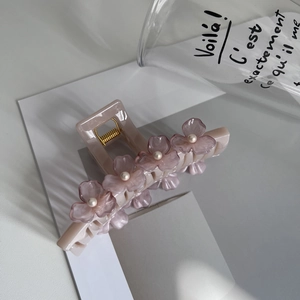 Detail view of pink large hair claw clip with purple acrylic flowers and pearls