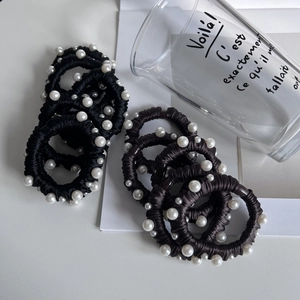 Détail d'élastiques à cheveux haute élasticité avec perles blanches et texture soie