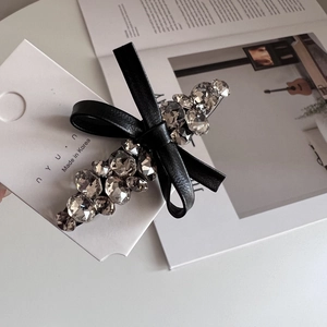 Elegant Korean style crystal bow hair clip with sparkling rhinestones on white magazine