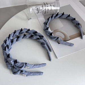 Detail view of the anti-slip inner comb and blue woven texture of the braided headband